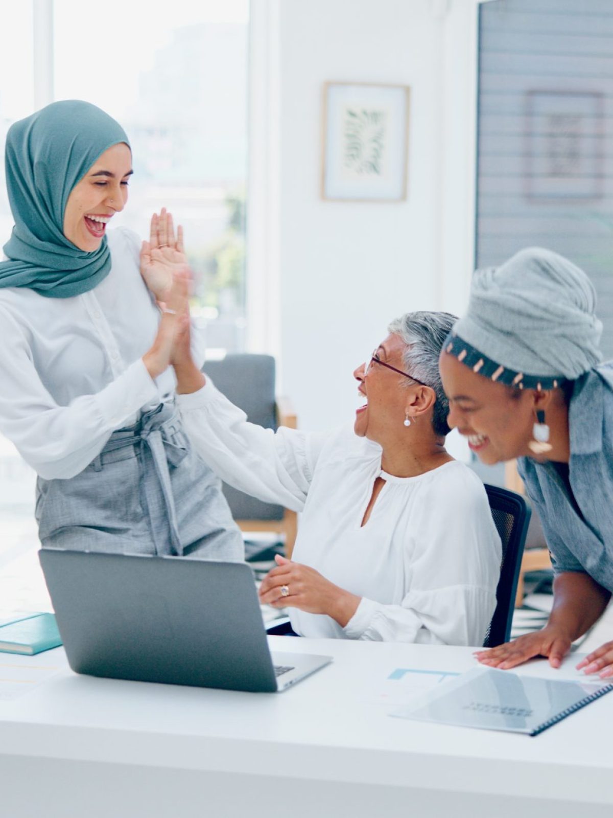 Creative business people, laptop and applause for good news, email or market sale in startup at the.