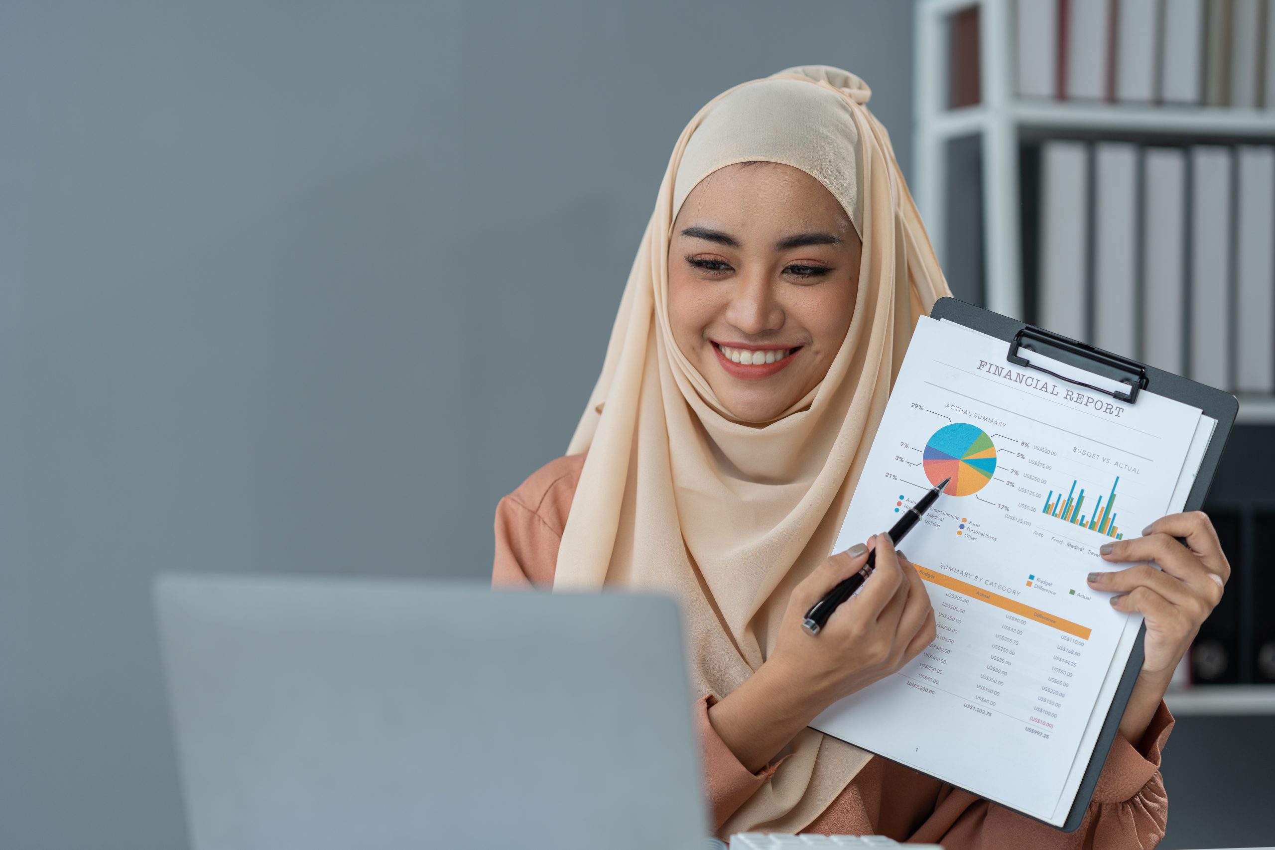 Motivated muslim businesswoman wearing hijab working on real estate project analyzing documents data graphing discussing presentation business reporting in office.